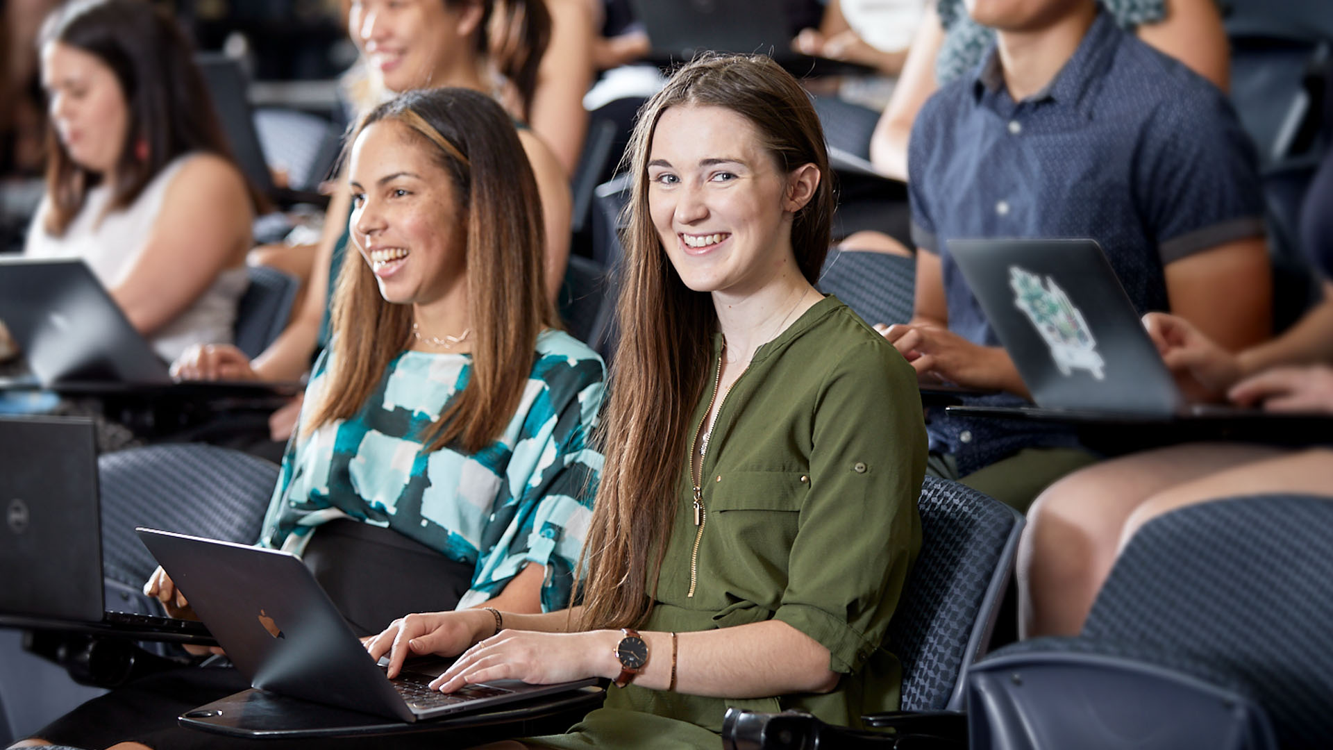 Multiple students sitting and studying in a classroom.
